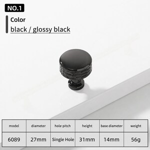 May include: A glossy black cabinet knob, model 6089, featuring a round top and a textured side. The knob has a 27mm diameter, 31mm height, 14mm base diameter, and weighs 56g. It is a single hole installation piece with a smooth, reflective finish.