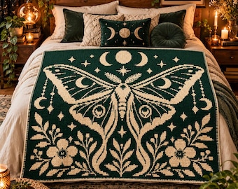 May include: A rectangular crochet blanket featuring a dark green background with a large, cream-colored moth design centered on the fabric. The moth is surrounded by floral motifs, stars, and moon phases, creating a symmetrical pattern across the textile.
