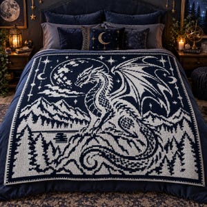Può includere: Una coperta lavorata a maglia blu scuro e bianca raffigurante un grande drago appollaiato su una scogliera rocciosa. Il design include una luna piena, un cielo stellato, una catena montuosa e una foresta di pini. La coperta è rettangolare.