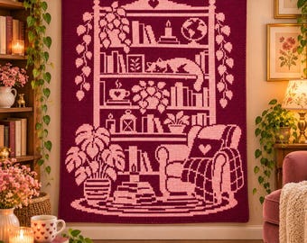 May include: A dark magenta and light pink crochet wall hanging featuring a detailed bookshelf design. The pattern displays shelves filled with books, potted plants, a globe, a candle, and a cat resting on a shelf, with an armchair below.