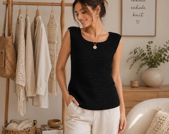 May include: A sleeveless black knit top with a wide scoop neckline and a textured garter stitch pattern. The garment features thick shoulder straps and a straight hemline, providing a clean and simple silhouette for everyday wear.