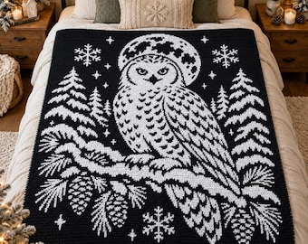 May include: A black and white crocheted blanket featuring a large owl perched on a pine branch. The design includes a full moon behind the owl, surrounding pine trees, and various snowflake patterns scattered across the dark background.