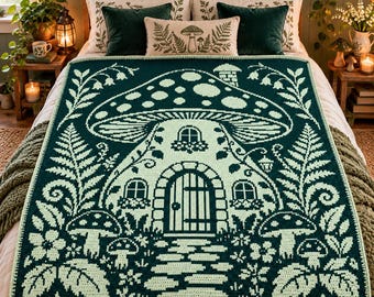 May include: A rectangular crochet blanket featuring a dark green and light green color scheme. The design displays a large mushroom-shaped house with a central door, windows, and a stone path, surrounded by ferns, flowers, and smaller mushrooms.