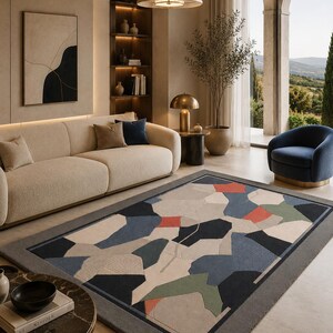May include: A rectangular area rug featuring a geometric pattern of interlocking shapes in shades of navy blue, sage green, terracotta orange, and cream, bordered by a solid dark gray frame with a textured, low-pile surface finish.