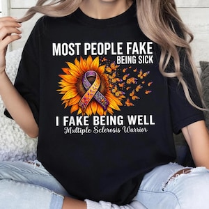 Può includere: Una t-shirt nera con un grande girasole e un nastro di sensibilizzazione viola e arancione al centro. Farfalle arancioni volano via dal fiore. Il testo recita: MOST PEOPLE FAKE BEING SICK I FAKE BEING WELL Multiple Sclerosis Warrior.