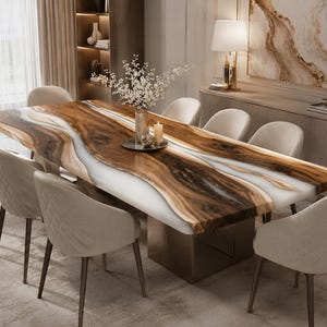 May include: A rectangular dining table featuring a live edge wood slab with a central white resin river inlay, supported by a solid metallic base. Six upholstered cream-coloured chairs with quilted backrests are arranged around the table.