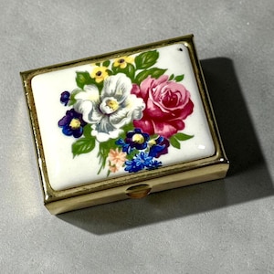 Vintage pillendoosje met bloemenmotief en spiegel, goudkleurig metaal, twee compartimenten, toilettas uit de jaren 70.