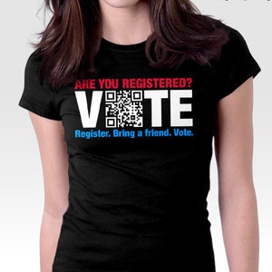 May include: Black t-shirt with a white graphic that says "ARE YOU REGISTERED? VOTE" with a QR code in the middle of the word "VOTE". The text "Register. Bring a friend. Vote." is below the graphic.