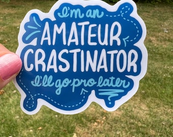 May include: A blue and white sticker with the text "I'm an amateur crastinator I'll go pro later" in a handwritten style.