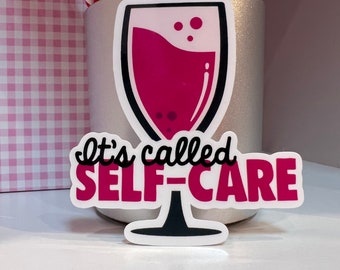 May include: A white sticker with a pink wine glass and the text "It's called self-care".