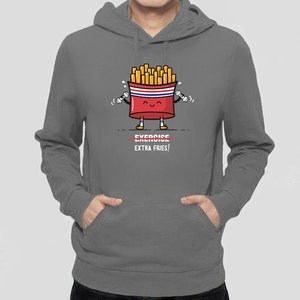 May include: A gray hoodie with a cartoon image of a french fry container holding dumbbells. The container has a smiling face and the text "EXERCISE EXTRA FRIES!" is printed below the image.
