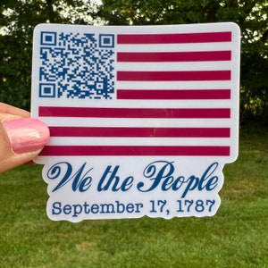 May include: A white sticker with a red, white, and blue American flag design. The sticker has a QR code in the top left corner and the text "We the People September 17, 1787" in blue cursive lettering.
