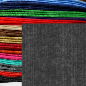 May include: A stack of colorful fabric in shades of purple, yellow, blue, green, red, brown, pink, and teal. A dark gray textured fabric is on the right side of the image.