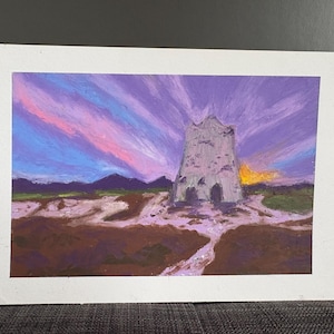 Può includere: Un dipinto rettangolare su carta che raffigura una torre di pietra in un paesaggio sotto un cielo al tramonto viola e rosa vibrante. Il primo piano presenta texture del terreno marrone terroso e viola chiaro, con montagne scure all'orizzonte.