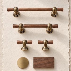 May include: A collection of cabinet hardware including two long bar pulls, two T-shaped knobs, one circular brass knob, and one rectangular wooden block. Each piece features a combination of dark brown wood and antique brass metal components.