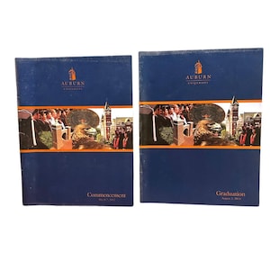May include: Two blue Auburn University commencement and graduation programs. The covers feature the university logo, a photograph of graduates, a campus clock tower, and an eagle. The text reads Commencement May 6, 2012 and Graduation August 2, 2014.