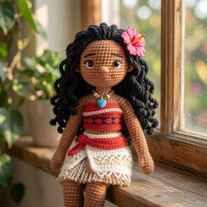 May include: A handcrafted crochet doll with dark curly hair, a pink hibiscus flower accessory, and a brown complexion. The doll wears a red patterned tube top, a red waist tie, and a white skirt with fringe, accented by a blue heart pendant necklace.
