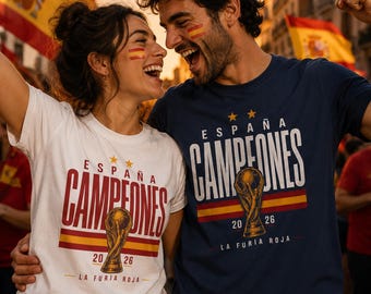 May include: A white t-shirt and a navy blue t-shirt, both featuring the text ESPAÑA CAMPEONES, a graphic of a gold trophy, the years 20 26, and the text LA FURIA ROJA, with a horizontal red and yellow stripe design across the chest area.