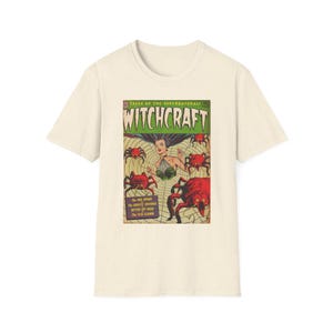 以下が含まれることがあります： Witchcraftというタイトルのヴィンテージコミックの表紙がプリントされた、クリーム色の半袖Tシャツ。表紙のアートには、クモの巣の上にいる大きな赤いクモに囲まれた人物が描かれており、Tales of the Supernaturalというテキストも含まれています。