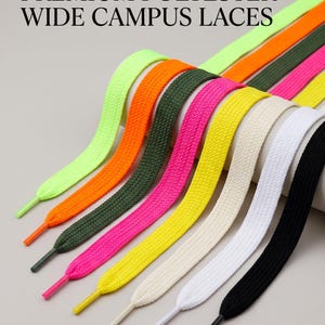 Può includere: Una collezione di lacci larghi e piatti in poliestere in vari colori, tra cui giallo neon, arancione, verde oliva, rosa acceso, giallo brillante, crema, bianco e nero. Il testo PREMIUM POLYESTER WIDE CAMPUS LACES è stampato in alto.