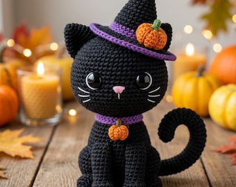 May include: A black crocheted cat figurine wearing a pointed hat with a purple brim and a small orange pumpkin accent. The cat has a purple collar with a matching pumpkin charm, large black eyes, and white stitched whiskers on a wooden surface.
