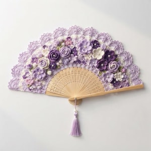 Op de afbeelding: Een vouwwaaier met een licht houten frame en een decoratief bovendeel gemaakt van lavendelkleurige en paarse gehaakte bloemen. Het bloemstuk bevat kleine witte parelaccenten en een bijpassend lavendelkleurig kwastje aan de onderkant.