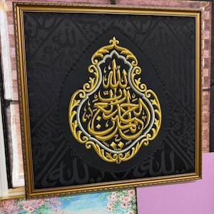 Könnte beinhalten: Ein quadratisches Wandbild mit schwarzem Stoffhintergrund und dezenter, tonaler arabischer Kalligrafie. In der Mitte befindet sich ein tropfenförmiges Stickmotiv aus goldenem und silbernem Garn mit komplexer arabischer Schrift in einem Goldrahmen.