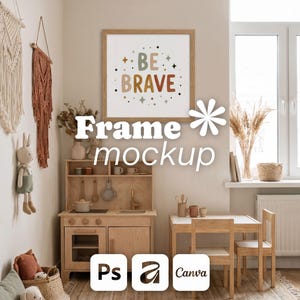 May include: A square wooden frame containing a white print with the text BE BRAVE in multicoloured letters, surrounded by small star and dot graphics. The frame is displayed on a wall above a wooden toy kitchen and a small table with two chairs.