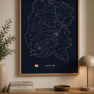 May include: A framed wall map of the Afrin region featuring a dark navy blue background with thin, light-colored lines depicting roads and geographical boundaries. The text AFRIN is printed in white, accompanied by a small flag icon.