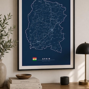 May include: A framed wall art print featuring a dark blue map of Afrin with white line details. The print includes the text AFRIN, a small flag icon, and additional text below the name, all presented in a clean, minimalist black frame.