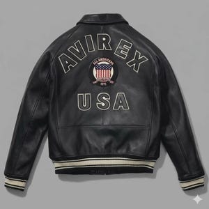 May include: A black leather jacket featuring the text AVIREX in white arched lettering across the upper back. Below the text is a circular patch with a United States flag and the words ALL AMERICANS ESTABLISHED 1975. The word USA is below the patch.