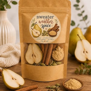 May include: A brown kraft paper pouch with a clear window containing dried pear slices, cinnamon sticks, ground ginger, and cardamom pods. The label features the text sweater weather spice and illustrations of the ingredients.