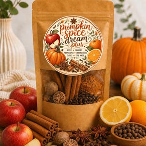 May include: A brown paper pouch containing a spice blend with a circular label reading pumpkin spice dream plus, featuring illustrations of apples, oranges, pumpkin, cinnamon sticks, cloves, and star anise, with visible spices inside.