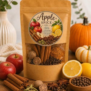 May include: A brown kraft paper pouch labeled Apple Spice containing a blend of dried ingredients. The circular label features illustrations of red apples, lemons, cinnamon sticks, cardamom, star anise, and allspice, with the text listing these ingredients.