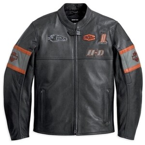 Puede incluir: Una chaqueta de moto de cuero negro con cuello mao, cremallera frontal completa y dos bolsillos con cremallera. El pecho muestra un gráfico de águila, un parche SYN3, un logotipo de número uno y texto H-D. Las mangas tienen rayas grises y naranjas.