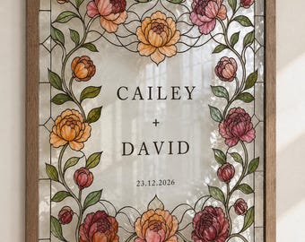 May include: A rectangular stained glass panel in a wooden frame featuring a floral border of pink and orange peonies with green leaves. The centre displays the text CAILEY + DAVID and the date 23.12.2026 in a dark serif font on clear glass.