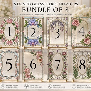 May include: A set of eight rectangular stained glass table numbers, numbered one through eight. Each piece features a unique floral border design with black numerals centered on a textured glass background, supported by small metal stands.