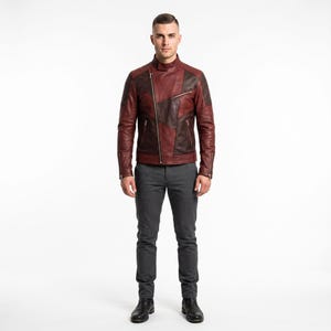 May include: A color-blocked leather jacket featuring a mix of deep burgundy and dark brown panels, a diagonal silver-tone zipper closure, a stand-up collar with a snap button, and zippered pockets, paired with slim-fit charcoal gray trousers.