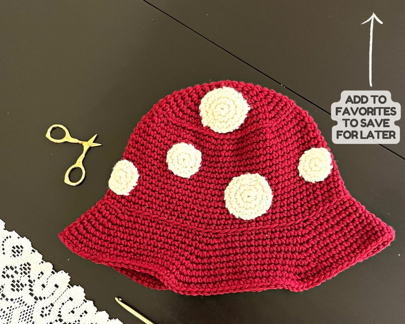 May include: A red crocheted hat with white crocheted circles. The hat has a wide brim and is made with a textured stitch.
