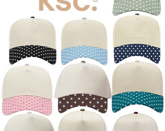 May include: A collection of eleven baseball caps featuring a cream-coloured crown and a curved brim with a white polka dot pattern in various colours including sage, black, light blue, navy, pink, brown, teal, red, olive, and maroon. The text kenz supply co ksc is visible.