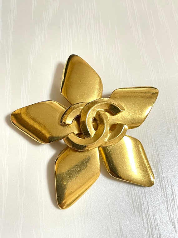 Vintage CHANEL Gold tone star, flower brooch with CC mark. Elegant