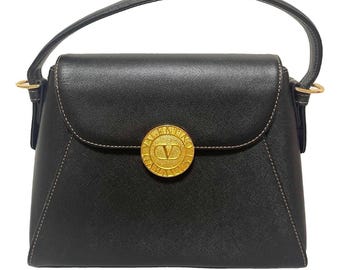 1990s. Vintage Valentino Garavani black leather handbag with golden round logo motif at front. Classic Valentino purse. 080512ac1