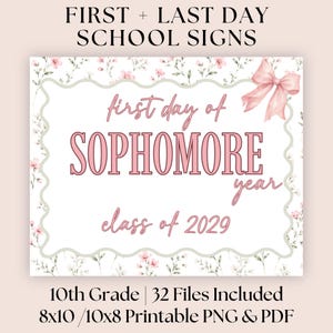 May include: A rectangular school sign featuring a white center with a scalloped border, decorated with pink floral patterns and a pink bow. The text reads: first day of SOPHOMORE year class of 2029. The design includes a light pink background.