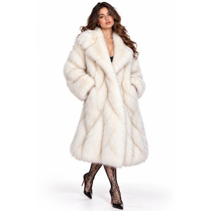 May include: A long, cream-colored faux fur coat featuring a thick, plush texture, wide lapels, and long sleeves. The coat has a full-length silhouette with a dense, shaggy appearance and deep side pockets, worn over black patterned tights and heels.