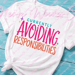 May include: A white short-sleeved t-shirt featuring the teal text "CURRENTLY" above the large pink text "AVOIDING" and the orange text "RESPONSIBILITIES". Small purple and teal star icons are positioned near the text on the front of the shirt.