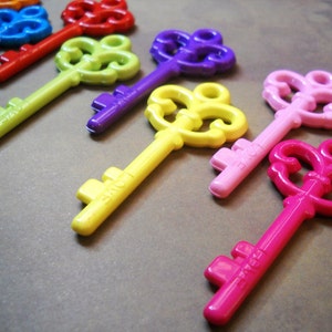 May include: A set of ten colorful, ornate, decorative keys. The keys are made of plastic and have a vintage style. The keys are arranged in a row, with the largest key at the top and the smallest key at the bottom.