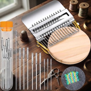 Op de afbeelding: Een metalen stopapparaat met een ronde houten basis, een doorzichtige plastic opbergkoker met meerdere zilveren naainaalden, een metalen vingerhoed, een kleine metalen schaar en een klein vierkantje van veelkleurige geweven stof.