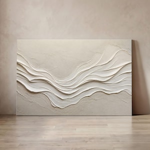 May include: A rectangular canvas featuring a textured, off-white and beige abstract painting. The artwork displays raised, sweeping horizontal layers of thick paint that create a wave-like, three-dimensional effect across the surface.