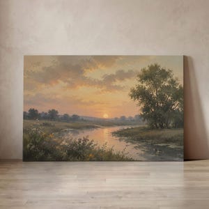 May include: A rectangular landscape painting depicting a serene river winding through a grassy meadow at sunset. The sky is filled with soft orange and yellow clouds, while a large tree stands on the right bank. The sun is low on the horizon.