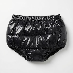 May include: A pair of black, high-waisted bloomers featuring a shiny, quilted, puffer-style fabric. The garment has an elasticated waistband and leg openings, creating a voluminous, rounded silhouette with horizontal stitched panels throughout.